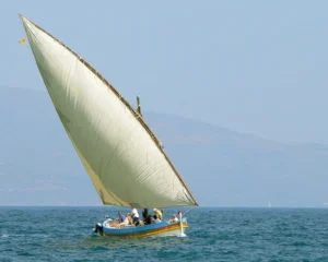 La forza del vento che gonfia la vela Barca a vela latina con la grande vela triangolare gonfia di vento mentre naviga