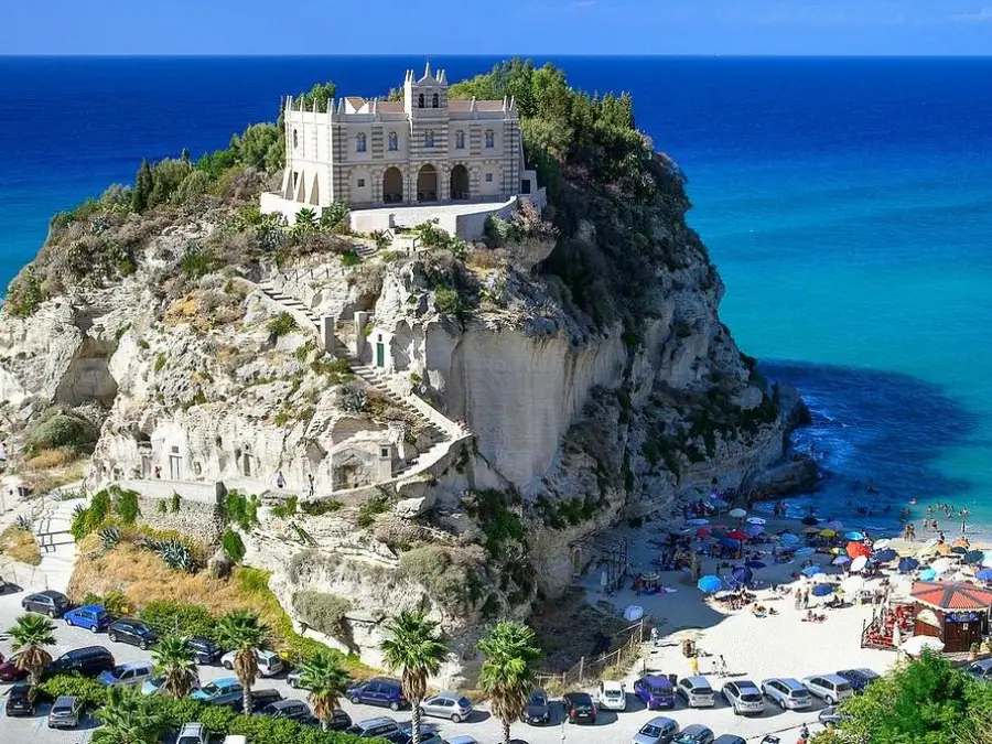 Vista panoramica della rupe di Tropea con il Santuario di Santa Maria dell'Isola e la spiaggia di sabbia bianca sottostante.