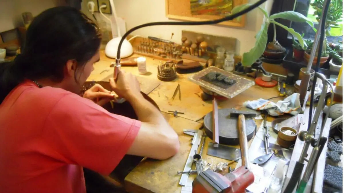 Orafo artigiano al lavoro nel suo laboratorio di oreficeria