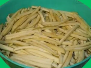 Raw Eggplant Strips Prepared for Pickling Thinly sliced raw eggplants in a container ready for salting and purging.